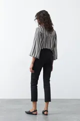 Pantalón de vestir negro de corte clásico, recto y levemente entallado, con largo hasta el tobillo.