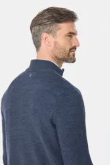 Buzo tejido de punto texturado en color azul marino, con cuello alto y medio cierre frontal.