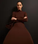 Vestido midi de punto acanalado, color negro, con cuello alto y mangas largas. Presenta un corte ajustado al cuerpo.