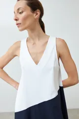 Maxi vestido bicolor, blanco en la parte superior y azul marino en la falda, sin mangas y con escote en V.