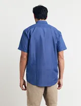 Camisa azul con microestampado, de corte clásico, manga corta y cuello abotonado.