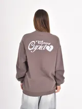 Buzo de cuello redondo, corte oversize y mangas largas con puños elásticos. Presenta un pequeño bordado en el pecho con la palabra 'Cupid' y un corazón.