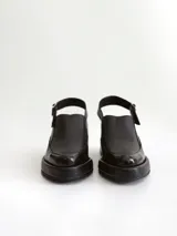 Zapato tipo slingback color negro, con plataforma y taco cuadrado. Presenta una puntera cuadrada y cierre con hebilla metálica en la tira trasera.