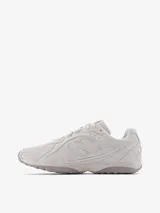 Championes urbanos New Balance modelo 204L, inspirados en el running de los años 2000, en color blanco con detalles en gris claro. Confeccionados en gamuza y malla, presentan la característica 'N' en los laterales y líneas arqueadas en el diseño.