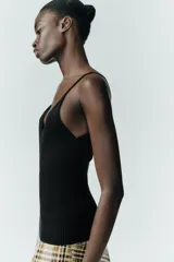 Top negro de punto con escote en pico y tirantes finos.