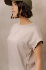 Sweater de punto color blanco, de corte relajado, con cuello redondo, manga corta japonesa de hombro caído y pretina ancha en la cintura.