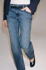 Jeans de tiro bajo y corte recto, confeccionados en denim con efecto lavado. Presentan cintura con trabillas, bolsillos delanteros y traseros, y cierre frontal con cremallera y botón.