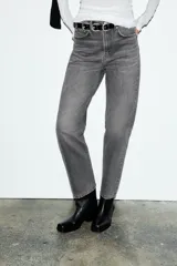 Jeans de tiro alto con corte mom fit, cinco bolsillos y cierre frontal con cremallera y botón metálico.