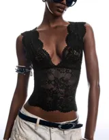 Top de encaje floral semitransparente, color negro, con escote profundo en V y terminaciones delicadas.