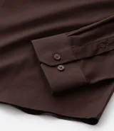 Camisa de corte slim, manga larga, con cuello camisero y cierre frontal de botones. Confeccionada en tejido plano de bambú, viscosa, poliéster y elastano.