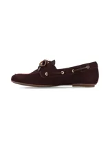 Mocasín tipo náutico de cuero nobuck color bordó, con cordones frontales, ojales metálicos dorados y costuras reforzadas en la puntera.
