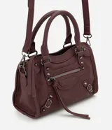 Bolsa tipo satchel color bordó de material sintético con detalles metálicos, bolsillos con cierre en el frente, asas de mano y correa larga ajustable.