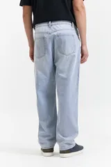 Jean de corte baggy con tiro medio, diseño amplio y holgado en piernas y cadera, con pasacintos y cierre frontal.