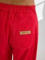 Pantalon de tiro medio-alto con pierna ancha, confeccionado en tela de rayón y poliéster. Presenta bolsillos plaque frontales, costuras a contratono y cierre frontal con botón.