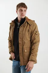 Campera de abrigo estilo parka color tostado, con capucha forrada desmontable, cierre frontal con botones y múltiples bolsillos funcionales en pecho, cintura y manga.