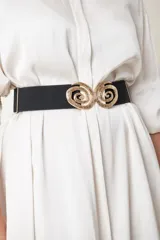 Cinto elástico marrón con hebilla metálica dorada formando dos espirales.