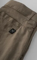 Bermuda tipo cargo color beige, con bolsillos laterales con solapa, trabillas para cinto y cierre frontal con botón y cremallera.