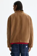 Campera de algodón color marrón con cuello camisero, cierre frontal, bolsillo superior con cierre y bolsillos laterales ribeteados.
