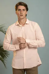 Camisa de manga larga en color salmón con estampado de pequeños motivos geométricos oscuros, cuello clásico y cierre frontal con botones.