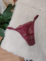 Microtanga confeccionada en encaje floral color bordó, con tiras laterales regulables y terminaciones en el mismo tono.