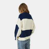Suéter de punto con diseño de bloques horizontales en azul marino y crema, corte oversized y cuello redondo. Presenta el logo de la marca bordado en el frente en color bordó.