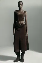 Top crop de escote recto y tirantes anchos, confeccionado en tejido con efecto ante. Presenta un diseño ajustado con cierre lateral mediante cremallera oculta.
