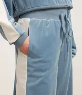 Pantalón wide leg de textura afelpada en color marrón, con cintura elástica ajustable mediante lazo y raya lateral en contraste.