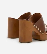 Sandalias de plataforma color marrón con tiras de cuero sintético y tachuelas doradas.
