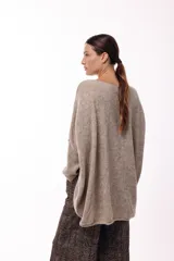 Sweater de punto con silueta amplia y relajada, cuello redondo y mangas largas con puños ajustados. Presenta un diseño de caída fluida y tejido suave.