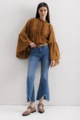 Pantalón jean de corte acampanado, tiro alto, color celeste y terminación desflecada.