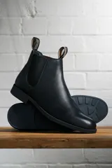 Botas Chelsea negras de cuero liso, con elásticos laterales y tiradores traseros con el nombre de la marca.