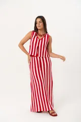 Falda larga tejida a rayas verticales rojas y blancas, con pretina elástica y tajos laterales.
