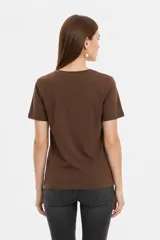 Remera blanca de manga corta y cuello redondo, confeccionada en algodón, con un diseño holgado y estampado frontal de estrella roja con textura y detalles de estrellas pequeñas.