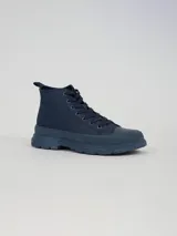 Botin de caña media con cordones, confeccionado en pana color azul marino. Presenta puntera reforzada y suela de goma con plataforma dentada del mismo tono.