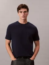 Remera de corte regular confeccionada en algodón, con cuello redondo y mangas cortas. Presenta un diseño minimalista con el logo de la marca sutilmente bordado en el pecho.