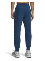 Pantalón tipo jogging Under Armour de corte ajustado, confeccionado en tejido de doble punto elástico y transpirable. Presenta diseño bicolor en tonos azules, cintura elástica con cordón interno, bolsillos laterales abiertos y un bolsillo lateral con cierre. Incluye logo de la marca en la parte superior.