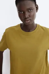 Remera oversized de algodón color verde militar, con cuello redondo ribeteado y hombros levemente caídos.