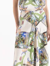 Pollera larga de corte evasé, con fondo blanco y estampado multicolor que incluye elementos de la naturaleza, arquitectura y la inscripción "Ciao Bella".