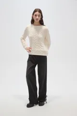 Sweater de punto color natural con diseño de ochos, cuello redondo y mangas largas de calce holgado.