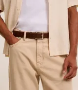 Cinturón de cuero negro liso con hebilla metálica plateada de forma rectangular.