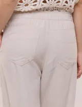Pantalón de lino blanco, marca Dash, con pretina ancha elastizada, lazo de ajuste y bolsillos inclinados en el frente.