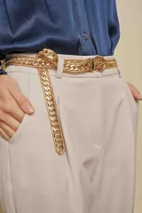 Cinturón de cadena metálica dorada con eslabones gruesos y cierre de hebilla ajustable.