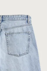 Jeans de denim de algodón en color azul con efecto desgastado, tiro medio y corte recto de ajuste holgado (loose fit). Cuenta con diseño clásico de cinco bolsillos y cierre frontal con cremallera y botón.