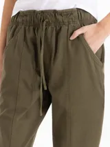 Pantalón de gabardina color bordó, de tiro medio con cintura elastizada y cordón regulable. Presenta calce relajado, corte recto y largo hasta los tobillos, con bolsillos laterales.