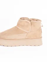 Bota corta tipo ugg con plataforma dentada, confeccionada en material gamuzado color beige con interior forrado en piel sintética.