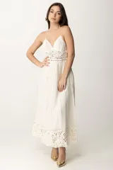 Vestido largo blanco con breteles finos, escote en V y detalle de tejido crochet calado en la cintura. La falda es plisada y termina con un borde de encaje ancho.