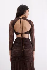 Top de encaje marrón con transparencias, mangas largas, cuello redondo y silueta ajustada al cuerpo, con diseño de espalda descubierta y lazos.