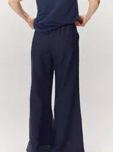 Pantalón de lino color tostado, de corte amplio y fluido con piernas acampanadas.