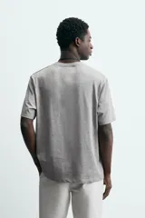 Camiseta de corte relajado confeccionada en algodón, con cuello redondo acabado en rib y manga corta.