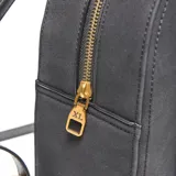 Mochila estructurada compacta de símil gamuza color gris oscuro, con doble asa corta superior y correas traseras regulables. Presenta herrajes metálicos dorados y el logo "XL Extra Large" en dorado en el frente. Cuenta con un compartimento principal con cierre superior y un bolsillo interno con cierre.